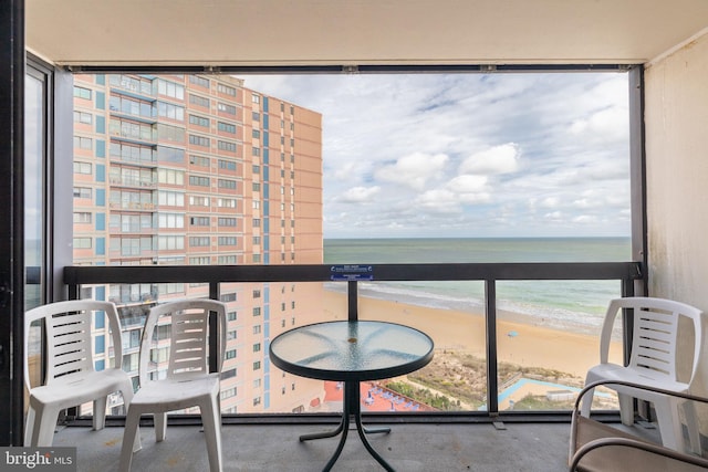 balcony featuring a water view and a view of the beach