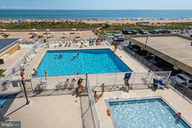 view of pool featuring a water view and a patio area