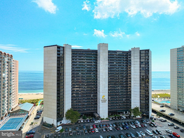 view of building exterior with a water view and a beach view