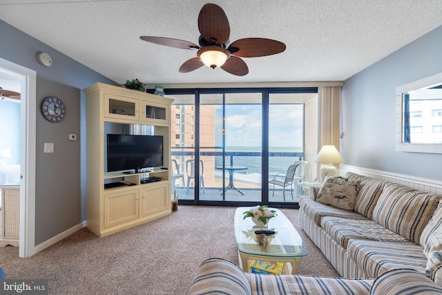 carpeted living room featuring a textured ceiling and ceiling fan