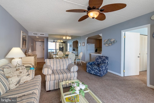 carpeted living room featuring ceiling fan with notable chandelier and a textured ceiling