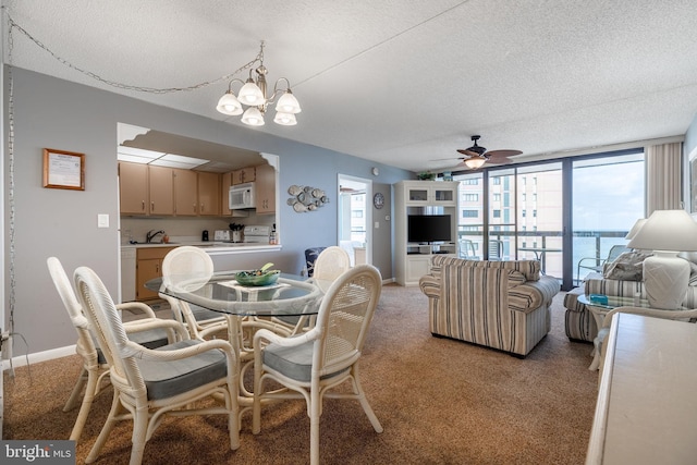 dining room with light carpet, a textured ceiling, ceiling fan with notable chandelier, and plenty of natural light