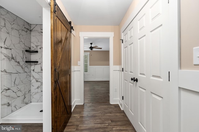 hall featuring dark wood-type flooring and a barn door