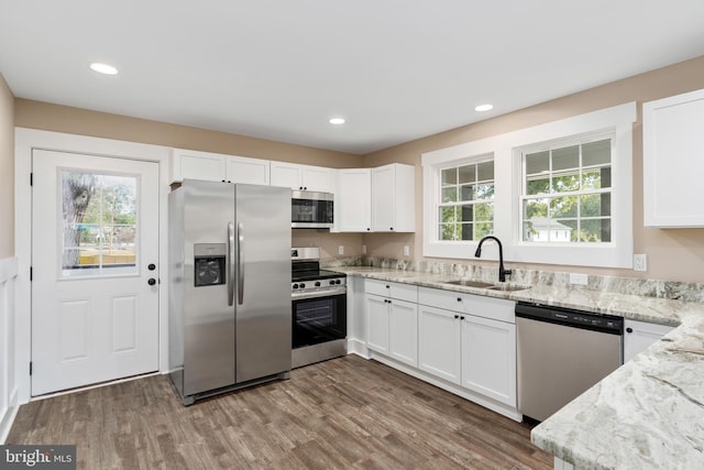 kitchen featuring a wealth of natural light, appliances with stainless steel finishes, and white cabinetry