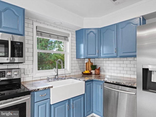 kitchen with blue cabinets, appliances with stainless steel finishes, and decorative backsplash