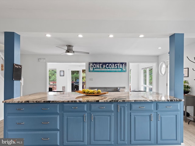 kitchen with plenty of natural light, a center island, light hardwood / wood-style floors, and blue cabinetry