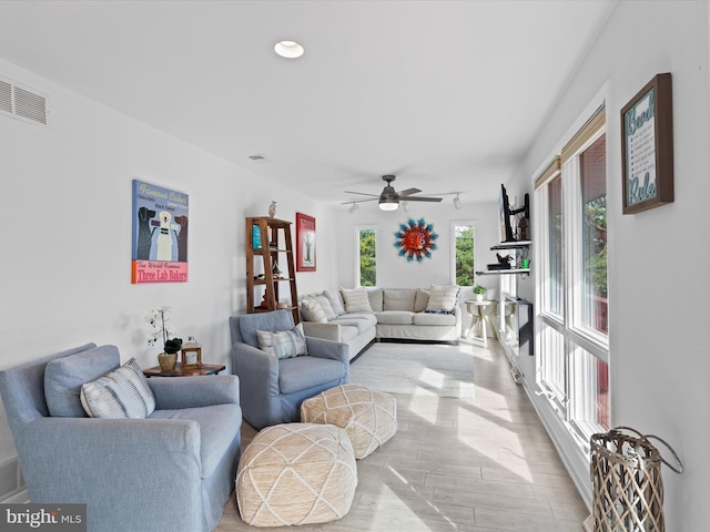 living room with ceiling fan and light hardwood / wood-style floors