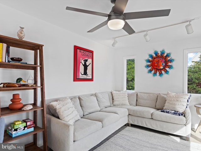 living room featuring rail lighting, hardwood / wood-style floors, and ceiling fan