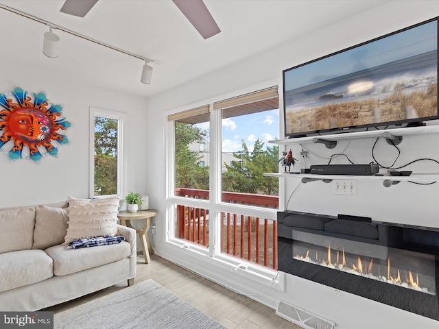 sunroom / solarium featuring rail lighting