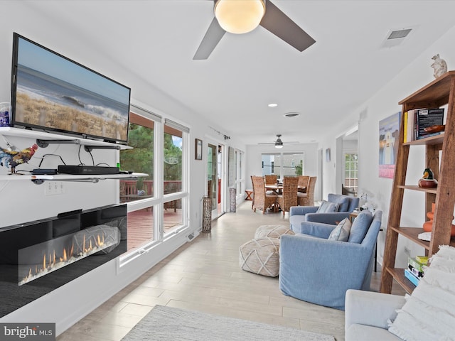 living room with ceiling fan and light hardwood / wood-style flooring