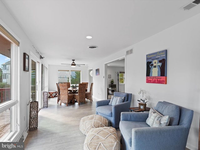 living room with light hardwood / wood-style flooring and ceiling fan