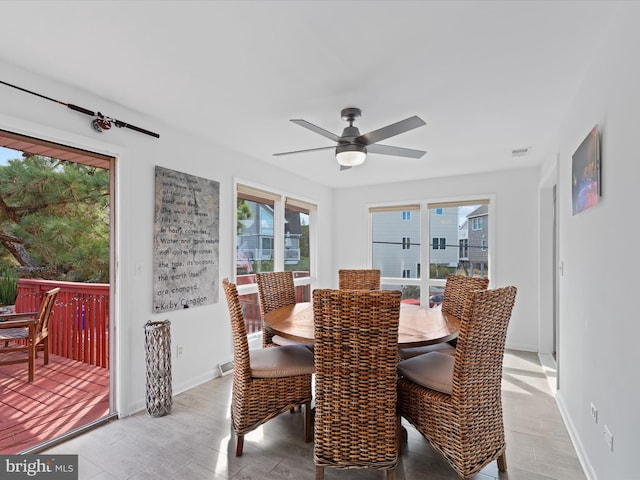 dining room featuring ceiling fan, a wealth of natural light, and light hardwood / wood-style flooring