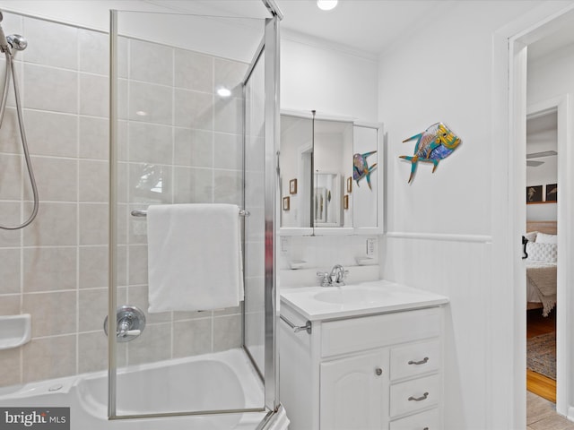 bathroom with hardwood / wood-style floors, bath / shower combo with glass door, and vanity