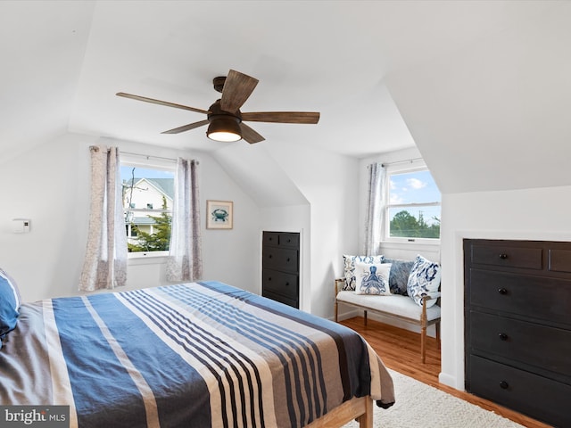 bedroom with vaulted ceiling, hardwood / wood-style floors, multiple windows, and ceiling fan