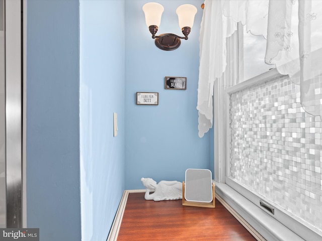 interior space with backsplash and hardwood / wood-style floors