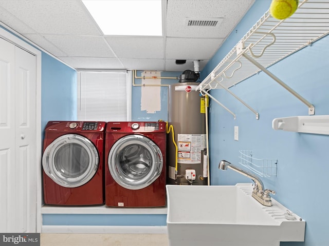 laundry area with gas water heater, sink, and washing machine and clothes dryer