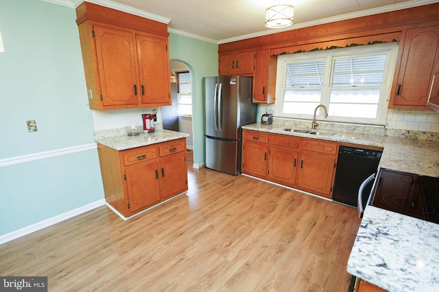 kitchen with black dishwasher, ornamental molding, sink, and stainless steel refrigerator