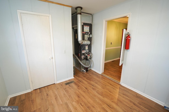 hall featuring light wood-type flooring and heating unit