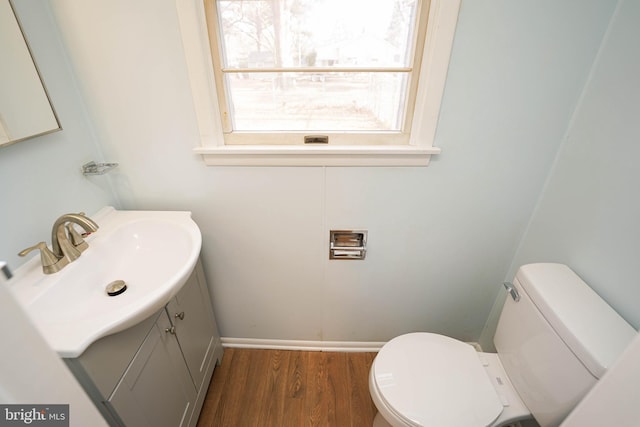 bathroom with hardwood / wood-style floors, vanity, and toilet