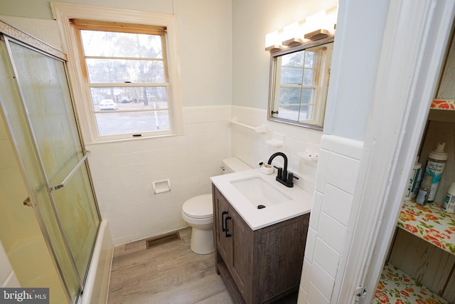 bathroom with toilet, hardwood / wood-style floors, vanity, and walk in shower