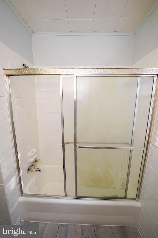 bathroom featuring hardwood / wood-style floors and shower / bath combination with glass door