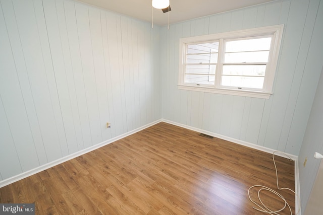 empty room with ceiling fan and wood-type flooring