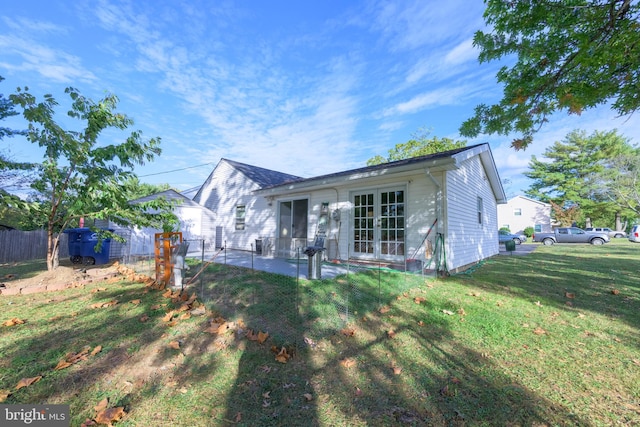 rear view of house with a shed, a yard, and a patio