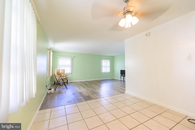 empty room with ceiling fan and light hardwood / wood-style flooring