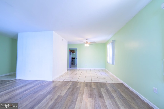 unfurnished room with ceiling fan and light wood-type flooring