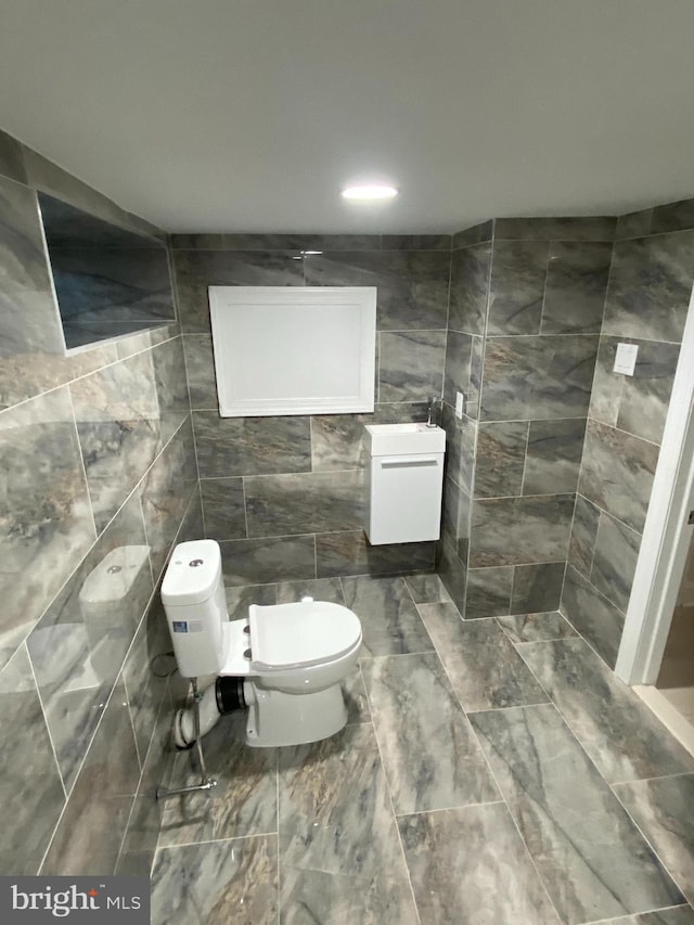 bathroom featuring toilet and tile walls