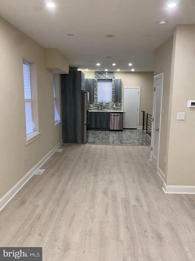 unfurnished living room with light hardwood / wood-style flooring and sink