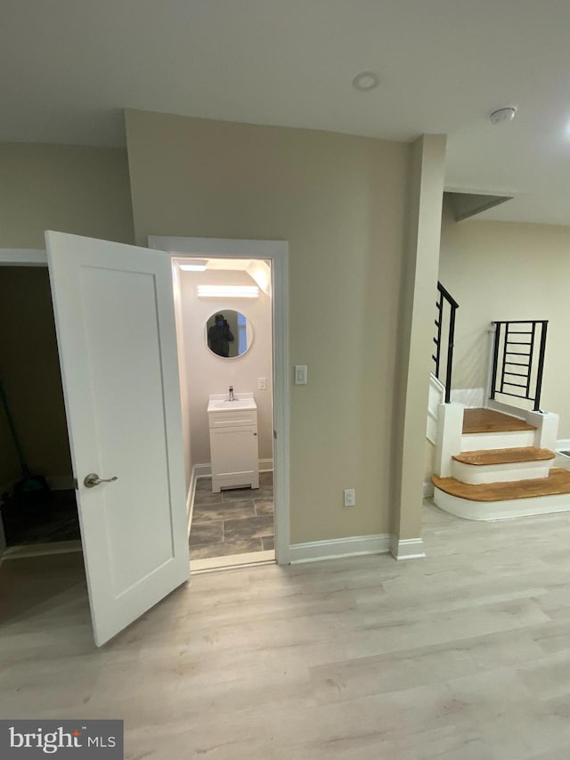 hallway with sink and light hardwood / wood-style flooring