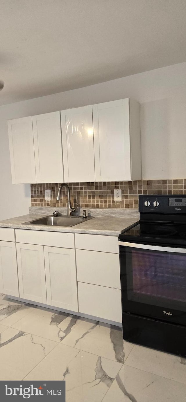 kitchen featuring white cabinets, backsplash, black electric range, and sink