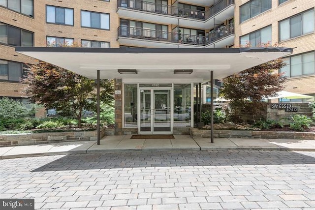 view of exterior entry featuring a balcony