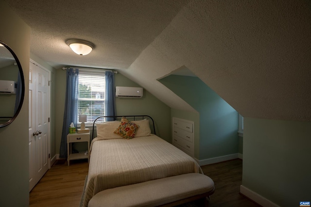 bedroom featuring a textured ceiling, lofted ceiling, dark hardwood / wood-style floors, and a wall mounted AC