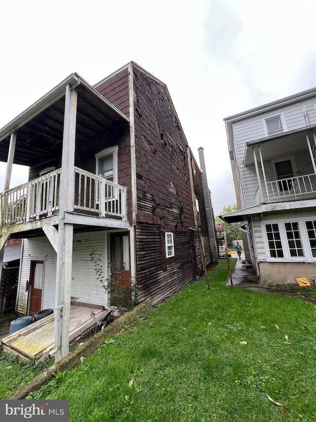 view of home's exterior with a lawn and a balcony