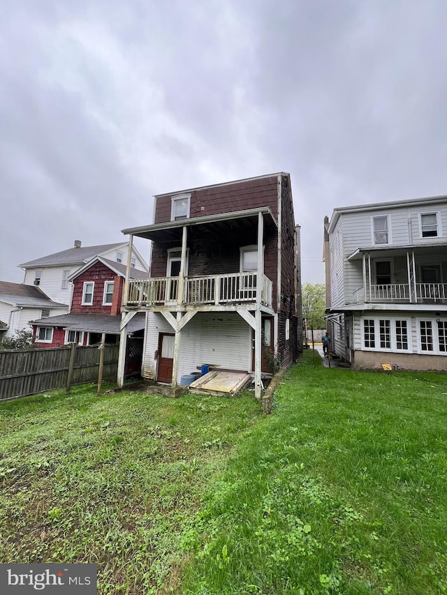 back of property featuring a deck and a yard