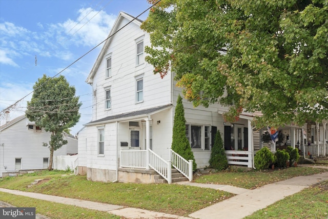 view of front of home with a front yard and covered porch