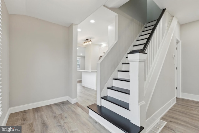 stairs featuring hardwood / wood-style floors