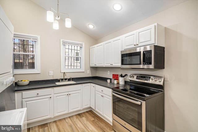 kitchen with white cabinetry, lofted ceiling, appliances with stainless steel finishes, and sink