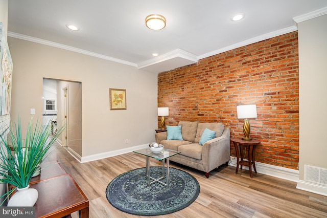 living room featuring crown molding, hardwood / wood-style flooring, and brick wall