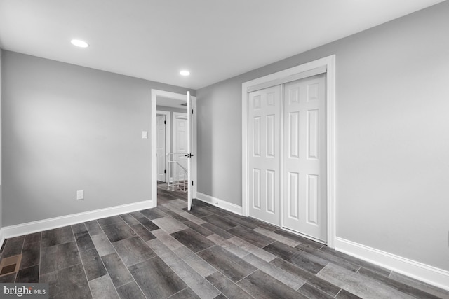 unfurnished bedroom featuring a closet and dark hardwood / wood-style floors