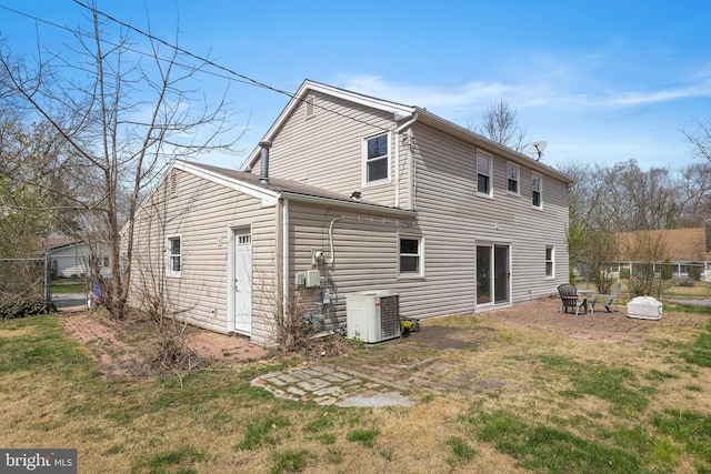 rear view of house featuring a lawn, a patio, and central AC unit