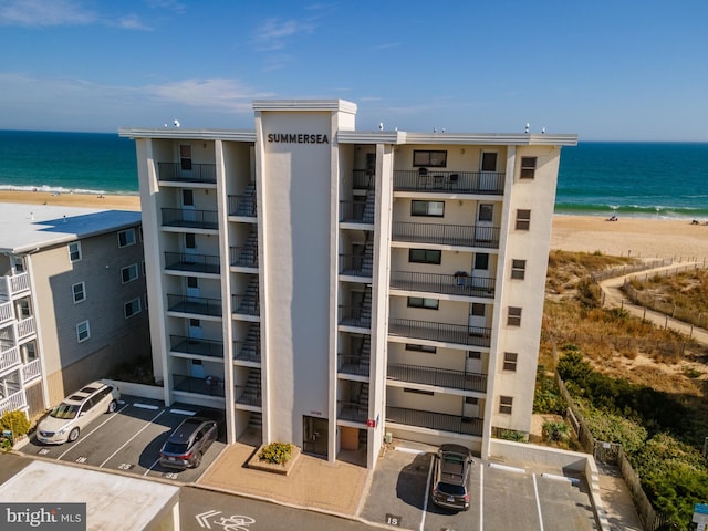 view of building exterior with a water view and a view of the beach