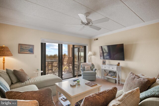 carpeted living room featuring crown molding and ceiling fan