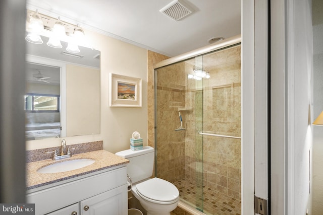 bathroom featuring vanity, walk in shower, and toilet