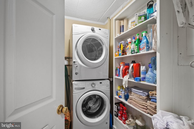 clothes washing area with stacked washer and clothes dryer, a textured ceiling, and ornamental molding