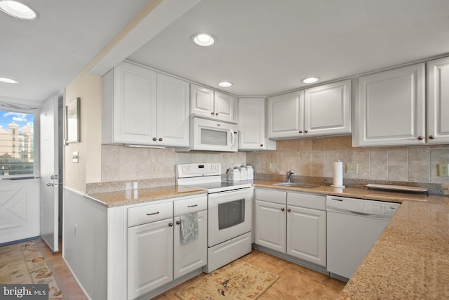 kitchen with light tile patterned floors, sink, white appliances, backsplash, and white cabinetry