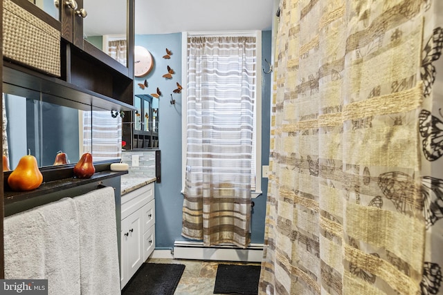 bathroom with baseboard heating, walk in shower, and vanity