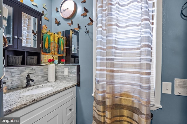 bathroom with vanity and tasteful backsplash